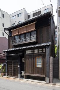 an old wooden building with a balcony on a street at Natsume an Machiya House in Kyoto