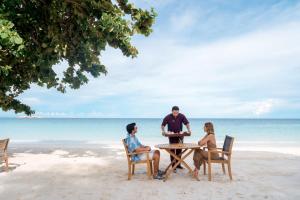 a group of three people sitting at a table on the beach at Paradee in Ko Samed