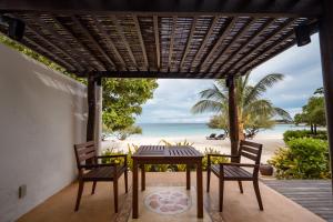 a table and chairs on a porch with the beach at Paradee in Ko Samed
