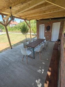 a wooden table and chairs on a patio at Villa Kally Fruska Gora in Velika Remeta