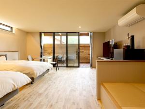 a hotel room with two beds and a desk and a television at Hotel 4CROWNS-GRAND ブロンズプラン in Katsuyama