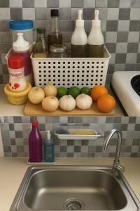 a kitchen counter with a sink and some onions at Bahay Domingo Guesthouse in Bagac +1 photo