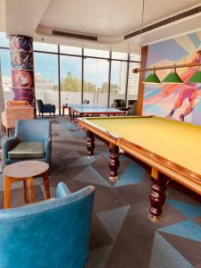 a billiard room with several tables and couches at HomeyStays 2BHK Lakeside walk in Rāi