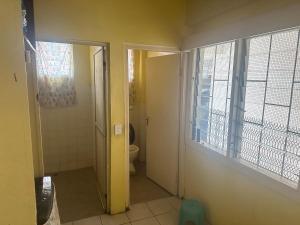 a bathroom with a toilet and a window at wen in Nadi
