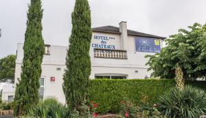 a white building with trees in front of it at Logis Hôtel Restaurant des Châteaux in Azay-le-Rideau