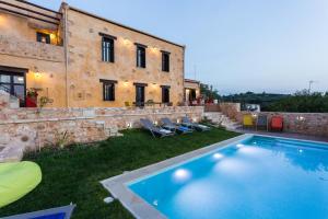 a villa with a swimming pool in front of a building at ERONDAS Cretan Country Villas in Achlades