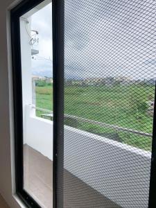 a window with a view of a green field at Metro Naga Bnb 