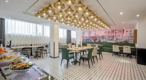 une salle à manger avec des tables et des chaises dans un restaurant dans l'établissement City Comfort Premier Hotel Qinzhou Lingshan Traditional Chinese Medicine Hospital Gymnasium, à Lingshan