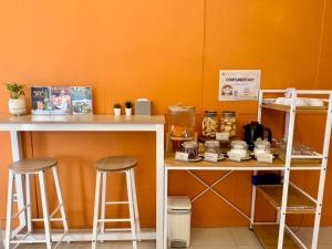 a counter with two stools and a table with food at Centro One Bangla in Patong Beach