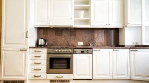 cocina con armarios blancos y horno en Apartment by the Old Town Square, en Praga