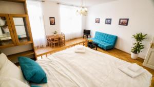 - une chambre avec un lit blanc et un canapé bleu dans l'établissement Apartment by the Old Town Square, à Prague