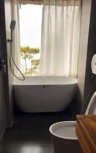 a bathroom with a bath tub and a window at Paàng Village - Thiên đường mây Tà Xùa in Bắc Yên