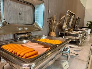 a tray of hot dogs and carrots in a kitchen at Centro One Bangla in Patong Beach