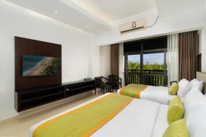 a hotel room with two beds and a flat screen tv at Kynrock Hotels & Resorts Kataragama in Kataragama