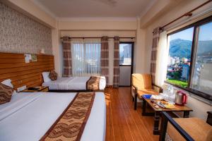 een hotelkamer met een bed en een groot raam bij Hotel Romantica in Pokhara