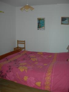 エルドゥヴァンにあるGites Erdeven Bretagne Sudのベッド(花の上にピンクのベッドカバー付)