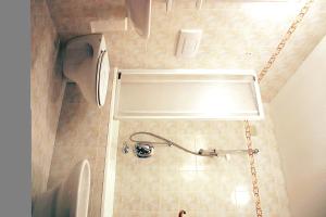 a bathroom with a shower with a toilet and a sink at Hotel Cima Dodici in Vigo di Fassa