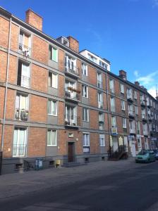 a large brick building with a car parked in front of it at Centrum Apartament in Gdańsk