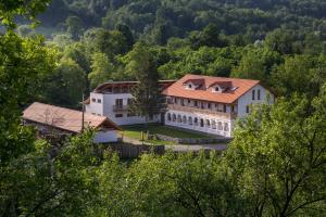 a large white building with a red roof at Hanul Vatra in Horezu