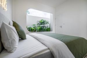 Un dormitorio blanco con una cama con ventana. en Dreamland Villas by RESIDE 3-Minute Walk to Beach, en Uluwatu 105 fotos más
