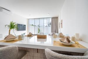 Una cocina blanca con una mesa y dos sillas. en Dreamland Villas by RESIDE 3-Minute Walk to Beach, en Uluwatu
