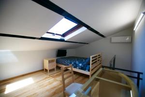 サレルノにあるB&B Divina Salernoの屋根裏のベッドルーム(ベッド1台、窓付)