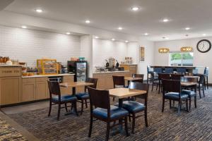 Un restaurante con mesas y sillas y una cocina. en Little Crow Resort & Conference, Trademark by Wyndham, en Spicer