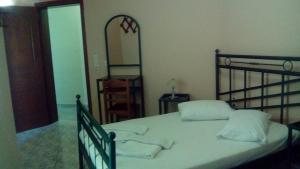a bedroom with a bed with white pillows and a mirror at Constantinos Studios in Chania Town