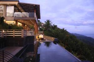 a house with a swimming pool next to a mountain at The Oriental Luxury Suites Tagaytay in Luksuhin