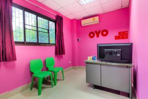 two green chairs in a room with pink walls at OYO 577 For Love Hotel in Samut Sakhon