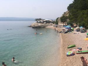 a beach with a bunch of people in the water at Studio Apartment Mrnjica in Brela +12 photos