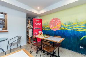 a dining room with a coca cola sign on the wall at OYO 422 Jane Homestay and Resort in Ban Kata
