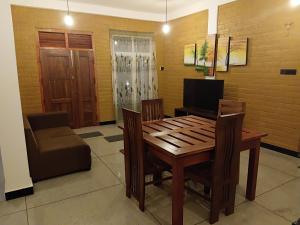 a dining room with a table and chairs and a television at Flight search villa and sea food restaurant in Habarana