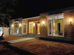 a brick building with illuminated windows at night at Flight search villa and sea food restaurant in Habarana
