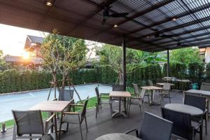 a group of tables and chairs under an umbrella at XOTEL in Khon Kaen