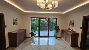 ein Wohnzimmer mit einem Kronleuchter und einer Glastür in der Unterkunft Willa Zacisze Szczawnica Apart in Szczawnica