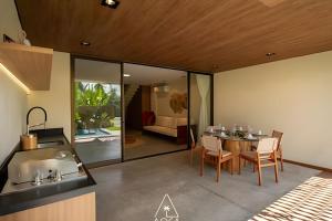 eine Küche und ein Esszimmer mit Tisch und Stühlen in der Unterkunft Casa Karoá, a Beira-Mar na Rota dos Milagres, Praia de Marceneiro in Barra do Camaragibe