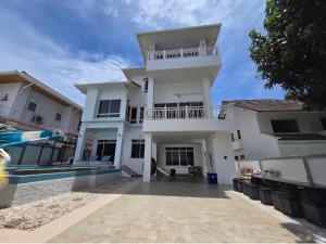 a large white house with a large driveway at White Sand Pool Villa Pattaya in Jomtien Beach