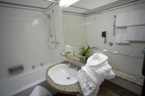 a white bathroom with a sink and a shower at Astoria Palace Hotel in Palermo