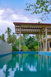 a swimming pool at a resort with a pavilion at NatureSurf Villas - Private Garden Retreat at Hiriketiya Beach Yoga, Surf & Relaxation in Dickwella