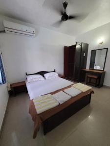 a bedroom with a bed and a ceiling fan at Samson Vacations At Karma Royal Palms Benaulim in Benaulim