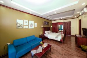 a hotel room with a bed and a couch at La Palm Garden - Luang prabang in Luang Prabang