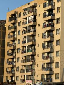 un gran edificio de apartamentos con balcones en un lateral. en The Airport Haven JKIA, en Nairobi
