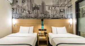 two beds sitting next to each other in a room at City Comfort Inn Guilin Railway Station in Guilin +203 photos