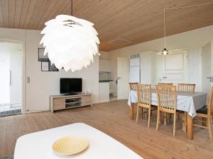 a dining room with a table and chairs and a chandelier at 6 person holiday home in Faaborg in Faaborg +33 photos