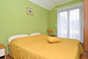 een groene slaapkamer met een bed met een gele deken bij Rustic house with private swimming pool in Pula