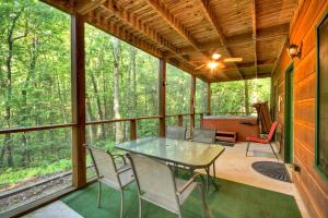 a screened in porch with a table and chairs at Papa Bear's Den in Cherry Log