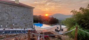 a house with a pool and a sunset in the background at Bosque da Fantasia in Baião