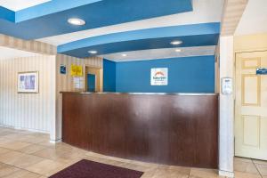 a hotel lobby with a reception desk and blue walls at Suburban Studios Branson On The Strip in Branson +46 photos