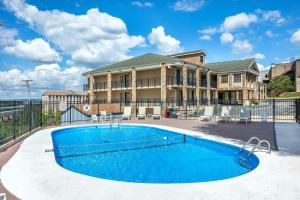 a swimming pool in front of a house at Suburban Studios Branson On The Strip in Branson